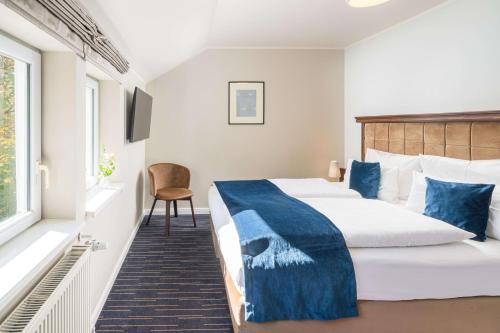 a hotel room with a bed and a window at QUARTIER 5 Hotel & Restaurant, Sächsische Schweiz in Kurort Gohrisch