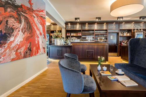 a room with a couch and chairs and a painting at QUARTIER 5 Hotel & Restaurant, Sächsische Schweiz in Kurort Gohrisch