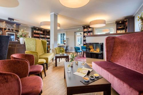 - un salon avec des chaises et une cheminée dans l'établissement Logis Hotel QUARTIER 5, Sächsische Schweiz, mit Restaurant, Café & Bar, à Gohrisch