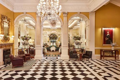 a lobby with a chandelier and a salon at Claridge's in London