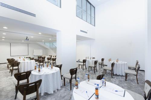 فندق فرج المدينه في المدينة المنورة: غرفة طعام بها طاولات وكراسي وشاشة عرض