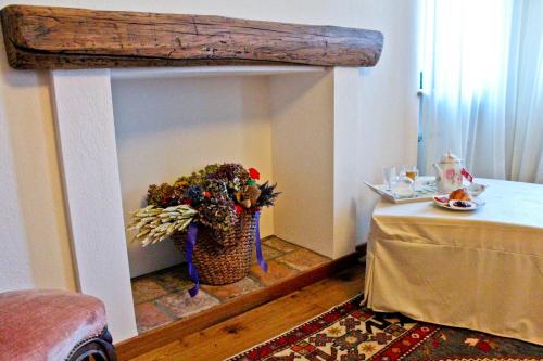 a living room with a fireplace with a table and a table sidx sidx at Agriturismo Rivella in Barbaresco