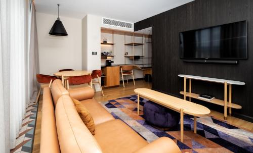 a living room with a couch and a tv at Hotel Indigo Adelaide Markets by IHG in Adelaide
