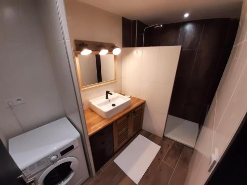 mała łazienka z umywalką i pralką w obiekcie Le Planard w mieście Rodez