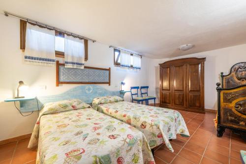 a bedroom with two beds and a wooden cabinet at Villa Maladroxia in Maladroscia