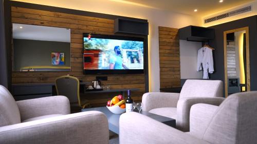 a living room with white couches and a television at Aitch Boutique Hotel - an LIH Hotel in Madaba