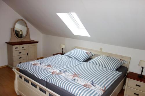 a bedroom with a bed with blue and white stripes at Ferienwohnung Sternenkieker in Krummhörn