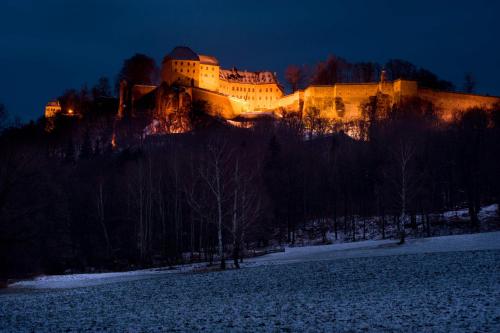 a large castle is lit up at night at QUARTIER 5 Hotel & Restaurant, Sächsische Schweiz in Kurort Gohrisch