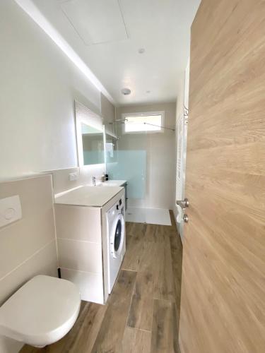 une salle de bain avec une machine à laver et un lavabo dans l'établissement L'Atelier des Rêves, à Veyrier-du-Lac