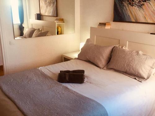 Una cama con un bolso encima. en Loft espectacular vista al mar, en Sitges
