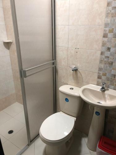 a bathroom with a shower and a toilet and a sink at Hotel Ecosuite Quibdó in Quibdó