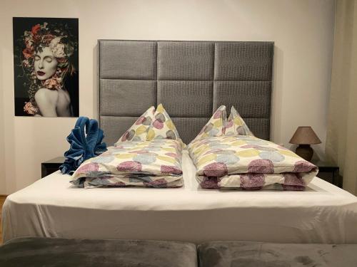 a bed with a headboard and two pillows on it at XuBa ApartmentRooms Messe Wien Prater in Vienna
