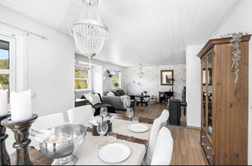 sala de estar con mesa, sillas y sofá en Sjarmerende familievennlig hus med 2 soverom en Kristiansand