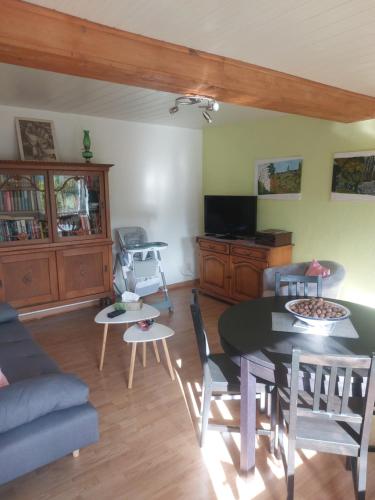 a living room with a table and a couch at Chez Nadine in Ranspach