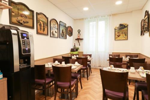 - un restaurant avec des tables et des chaises dans une salle dans l'établissement Hôtel Gloria, à Grenoble