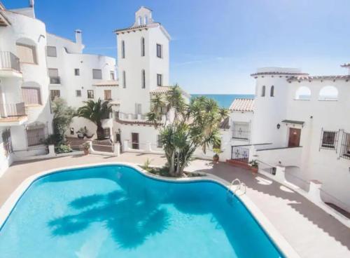una grande piscina di fronte a un edificio di Loft espectacular vista al mar a Sitges