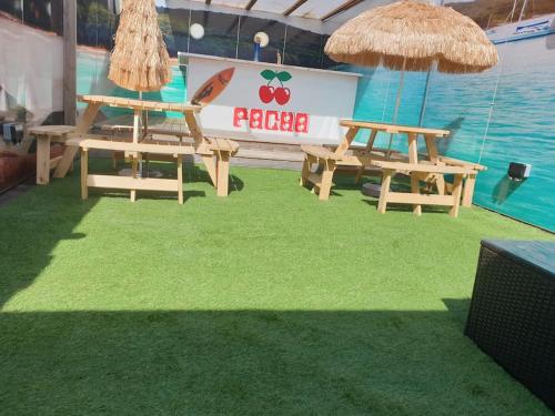 two picnic tables and umbrellas on a grass field at City CTR Penthouse - rooftop bar, sleeps 19 in Liverpool