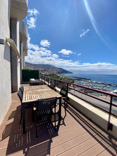 a table and chairs on a balcony with a view of the ocean at Rooftop Marina ll by Madeira Best Apartments in Funchal