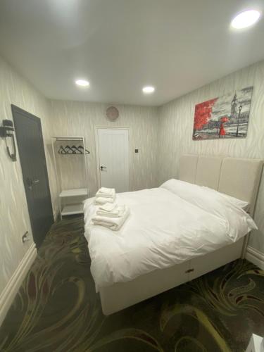 um quarto com uma cama branca e toalhas em Mannbuilding em Londres