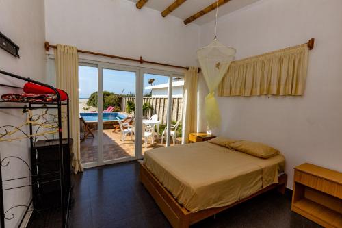 a bedroom with a bed and a balcony with a table at Casa Killa Vichayito in Vichayito