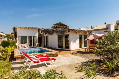 a villa with a swimming pool and a house at Casa Killa Vichayito in Vichayito