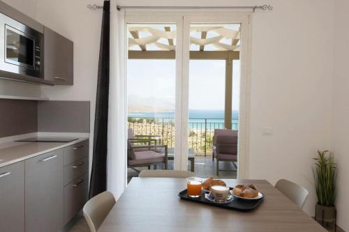 a kitchen with a table with a plate of food on it at La Blanca Resort & Spa in Castellammare del Golfo