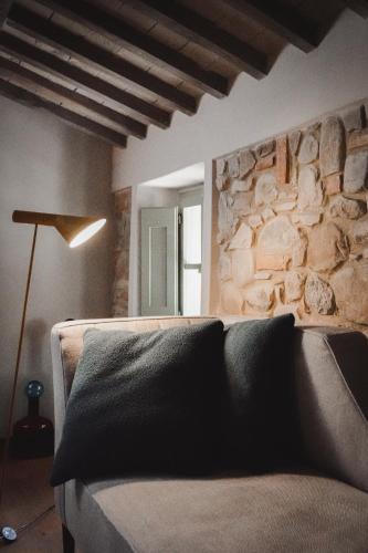 a living room with a couch and a stone wall at Vocabolo Moscatelli in Calzolaro