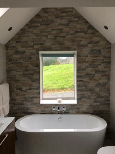 a bath tub in a bathroom with a window at Dream Cottage in Castletownbere