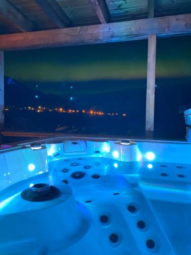 a jacuzzi tub with a view of the night at In the heart of the Lyngen alps, Holmen i Lyngen in Lyngseidet