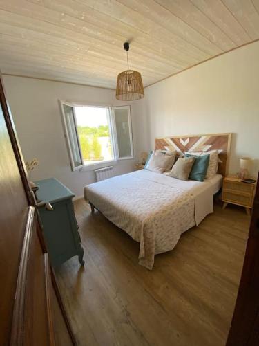 une chambre avec un grand lit et une fenêtre dans l'établissement Maison (4pers) confortable entre bassin et océan, à Arès
