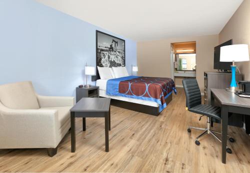 a hotel room with a bed and a desk at Super 8 by Wyndham Victoria - South - Hwy 59 in Victoria