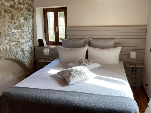 a bedroom with a large white bed with two pillows at Relais San Filippo in Sogaglia in Mulazzo