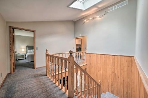 un pasillo con una escalera de madera y un dormitorio en Serene Riverfront Home with Torch Lake Access!, en Rapid City