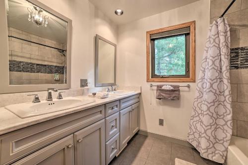 y baño con lavabo, espejo y ducha. en Serene Riverfront Home with Torch Lake Access!, en Rapid City