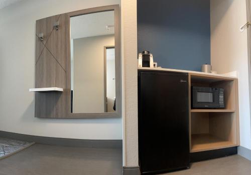 a bathroom with a mirror and a black microwave at Holiday Inn Express & Suites Marquette, an IHG Hotel in Marquette