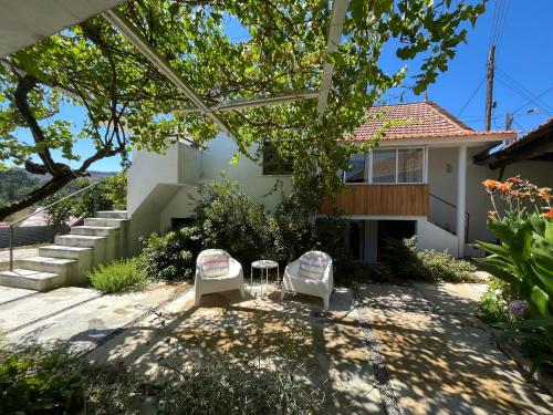 a house with two chairs in the yard at casAlice country house in Alvoeira