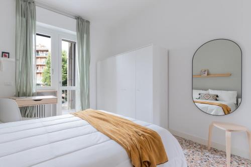 a white bedroom with a large mirror and a bed at Top Living Apartments - Carducci in Turin