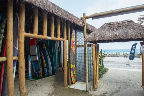a building with a bunch of surfboards on the beach at Longboard Paradise Surf Club in Rio de Janeiro