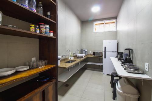 a large kitchen with a refrigerator and a sink at Longboard Paradise Surf Club in Rio de Janeiro