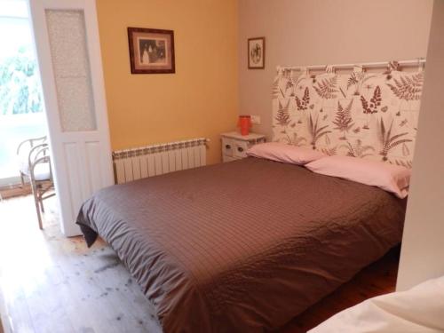 - une chambre avec un lit avec une tête de lit dans l'établissement Apartamento en Treceño, Cantabria, à Treceño