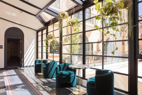a room with a table and chairs and large windows at el PRADO in Palo Alto