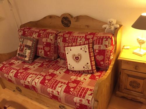 - un lit avec une couverture rouge et des oreillers dans l'établissement TERRASSES du GRAND HOTEL connexion WI-FI, à Luchon