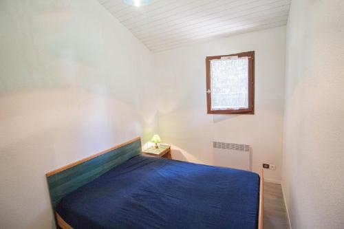 a bedroom with a bed with a blue blanket at A Deux Pas du Courant in Mimizan-Plage