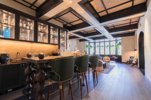 a bar in a restaurant with green chairs at el PRADO in Palo Alto