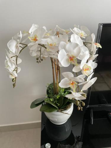 a vase filled with white flowers on a table at Has Hills Residence - 2 BEDROOMS CONDO with WiFi in Kajang