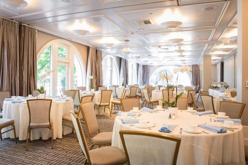 a room with white tables and chairs and windows at el PRADO in Palo Alto