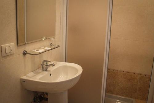 a bathroom with a sink and a mirror and a shower at Hotel Centrale in Este