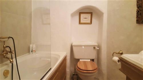 e bagno bianco con servizi igienici e vasca. di Cozy Old Town Historic House a Tallinn