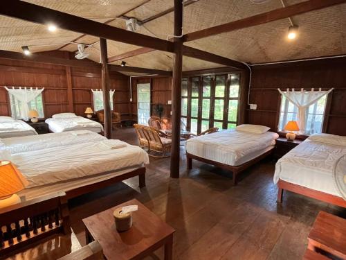 a large room with two beds and a table at Brown House Chiangdao in Chiang Dao