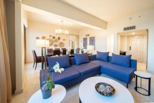 a living room with a blue couch and a table at Real Intercontinental San Salvador, an IHG Hotel in San Salvador